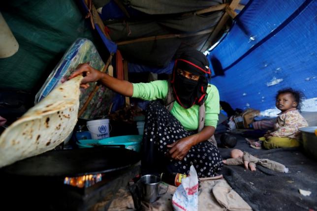A woman makes bread inside her tent at a camp for internally displaced people near Sanaa, Yemen, May 24, 2016. Reuters/Khaled Abdullah/File Photo