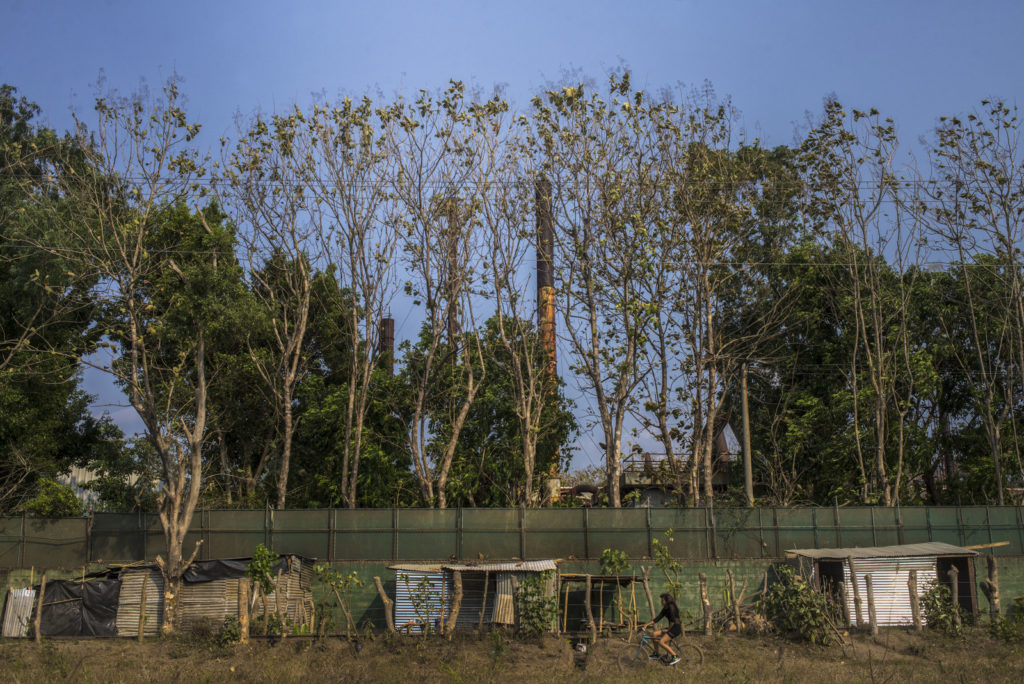 Shacks line the wall outside a closed-down battery factory in El Salvador. Juan Carlos for BuzzFeed News