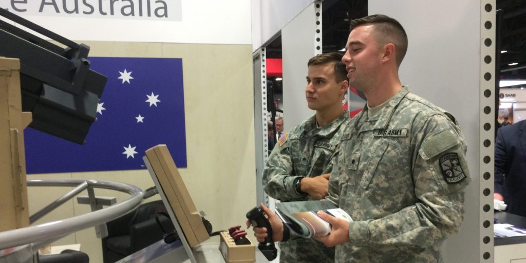 Soldiers from the U.S. Military adjust a 30 mm cannon at the EOS booth at the Association of the United States Army (AUSA) Annual Meeting & Exhibition.