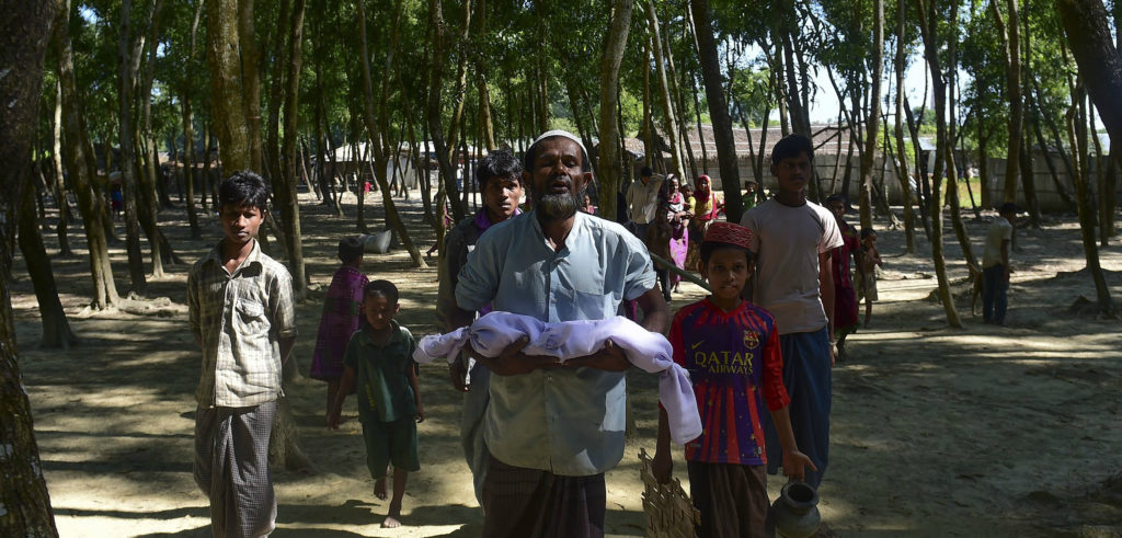 A Rohingya refugee from Burma carries the body of a six-month-old boy who died in a Bangladeshi refugee camp on November 26. MUNIR UZ ZAMAN/AFP/Getty Images